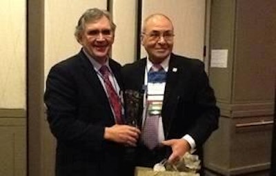 William Roenigk, senior vice president of the National Chicken Council, holds his Poultry Industry Lifetime Achievement Award next to Al Acunto, of Preferred Freezer Services and the immediate past president of the National Poultry & Food Distributors Association.