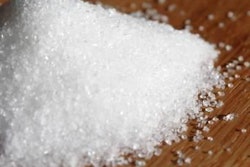 mound of sugar granules on wood surface