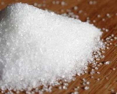 mound of sugar granules on wood surface