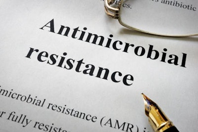 Paper with words antimicrobial resistance AMR and glasses. Medical concept.