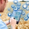 Composite Of Farmer In Field Accessing Data On Digital Tablet