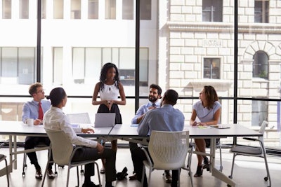 Young black businesswoman addressing colleagues at a meeting