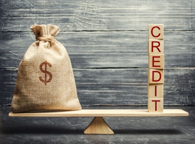 Money Bag And Wooden Blocks With The Word Credit On The Scales.