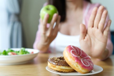 Young Girl Rejecting Junk Food Or Unhealthy Food Such As Donuts
