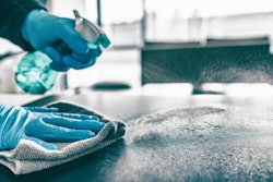 Cleaning home table sanitizing kitchen table surface with disinf