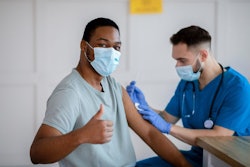 African American Man In Antiviral Mask Gesturing Thumb Up During