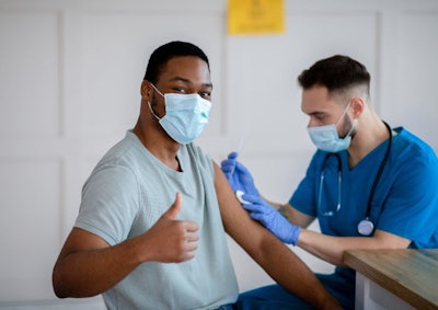 African American Man In Antiviral Mask Gesturing Thumb Up During