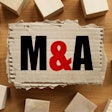 M And A Merger And Acquisition. Text On Torn Cardboard On Wood C