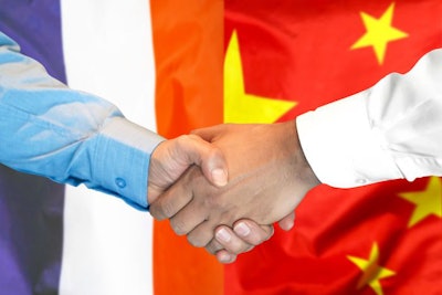 Business Handshake On The Background Of Two Flags. Men Handshake