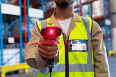 Mid section of mature Asian male worker showing barcode scanner