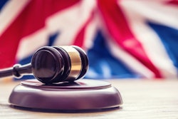 Judges wooden gavel with UK flag in the background. Symbol for jurisdiction.