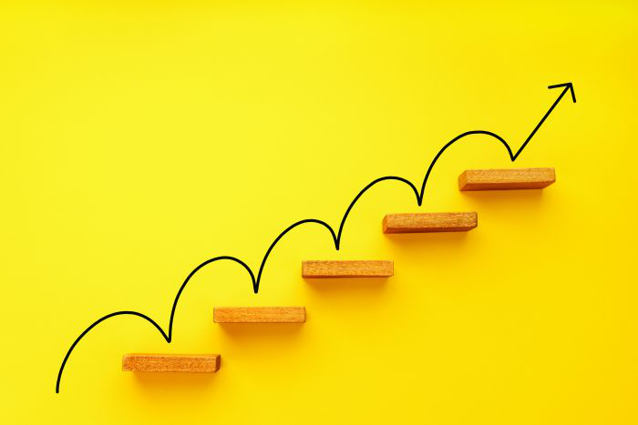 Rising arrow on staircase on yellow background. Growth, increasing business, success process concept. Copy space