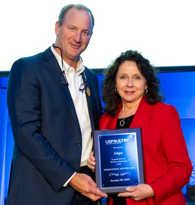 Marla Robison from Aviagen accepts the long-time exhibitor plaque from Mikell Fries (left), Claxton Poultry Farms and USPOULTRY chair.