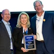 Greg Watt and Nancy Batio from WATT Global Media accept the long-time exhibitor plaque from Mikell Fries (right), Claxton Poultry Farms and USPOULTRY chair.