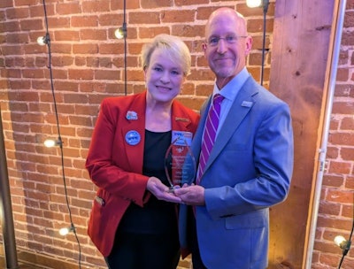 USPOULTRY Executive Vice President Gwen Venable presents the Lamplighter Award to Greg Watt, president and CEO of WATT Global Media.