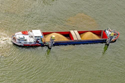 Cargo barge carrying grain on river, viewed from above