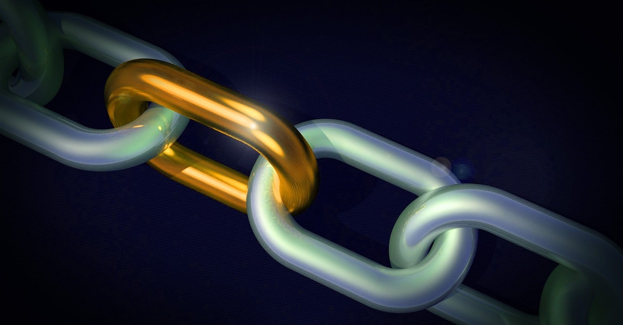 Metallic chain links with one golden link connected against dark background