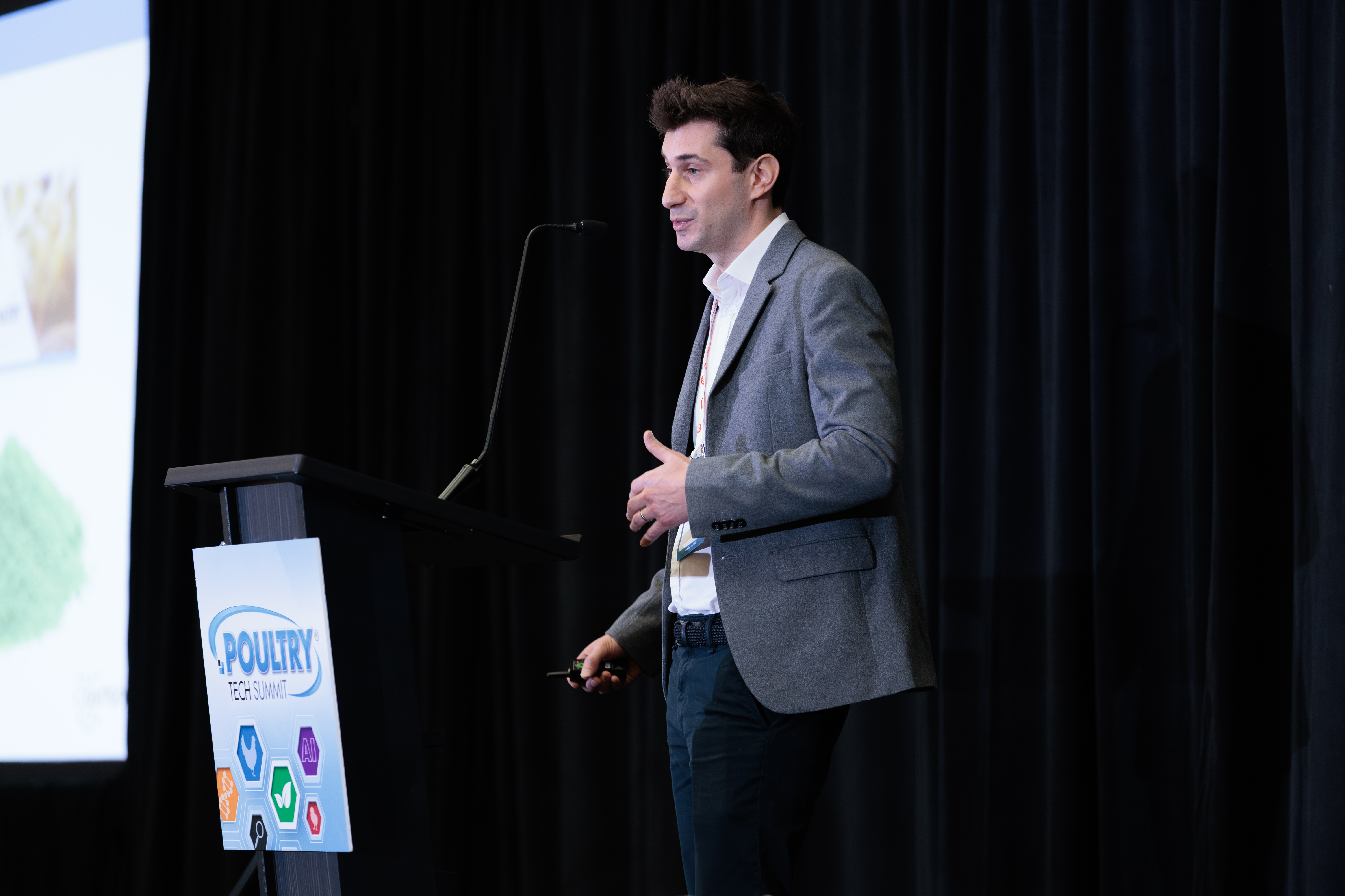 Speaker presenting at Poultry conference with branded event logo on podium