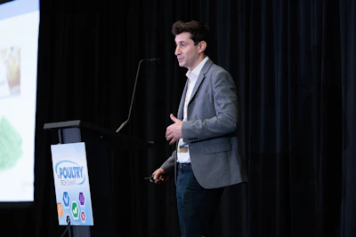 Speaker presenting at Poultry conference with branded event logo on podium