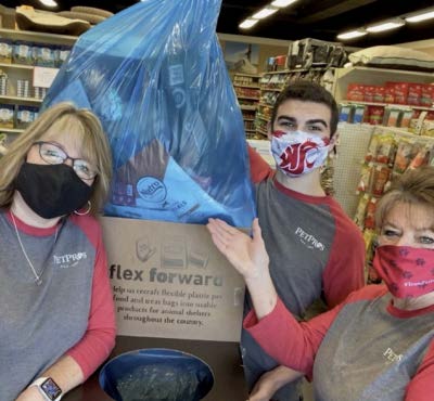 Three volunteers in masks holding donation box for community service project