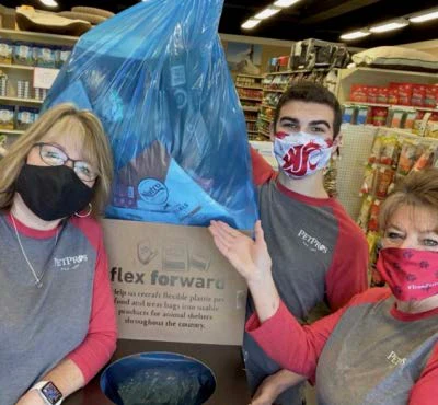Three volunteers in masks holding donation box for community service project