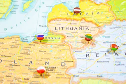 Political map of Eastern Europe showing Latvia, Lithuania, Russia, Poland, and Belarus with colored flag pins marking major cities.
