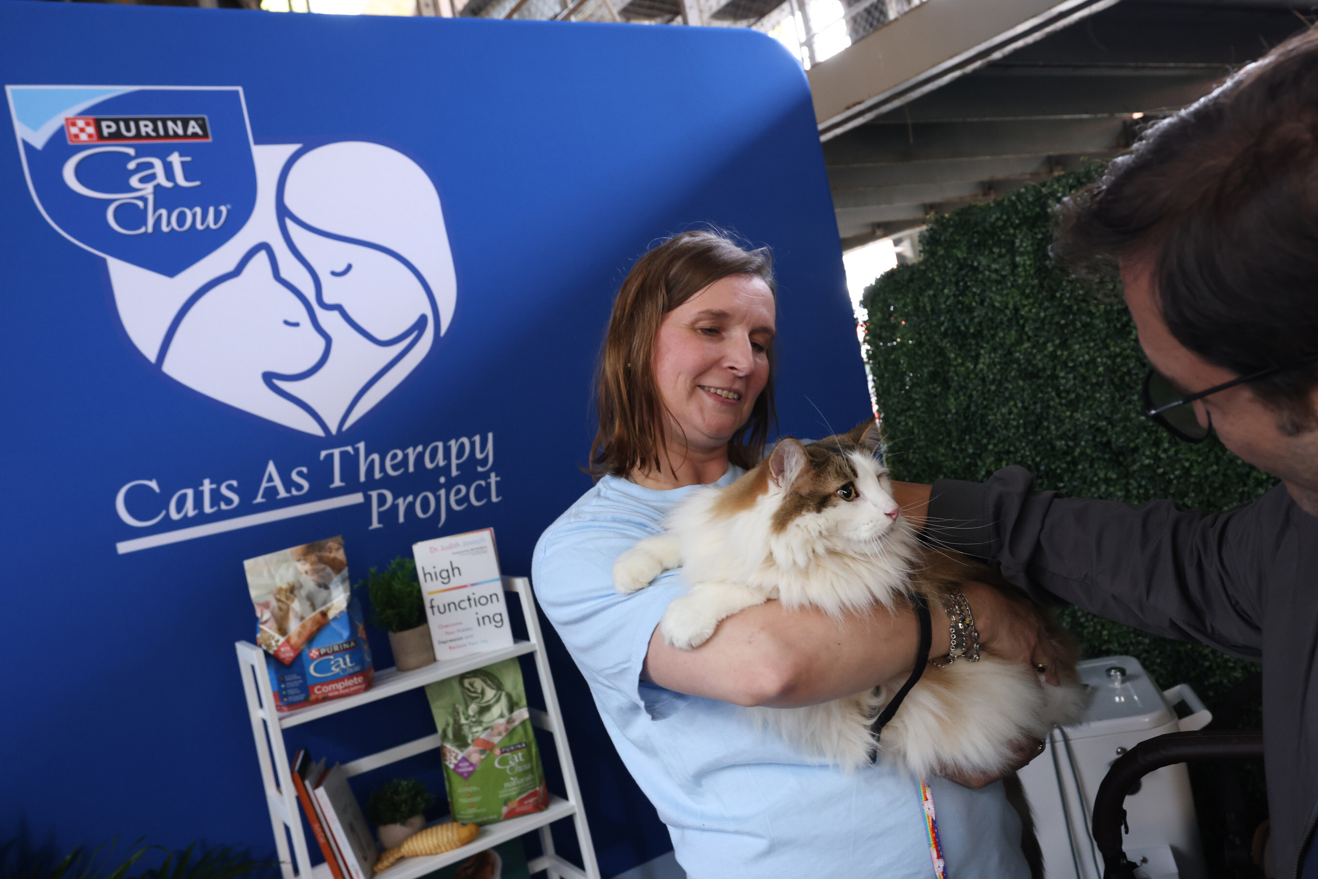 Woman holding a fluffy cat at Purina Cat Chow's Cats As Therapy Project promotional booth