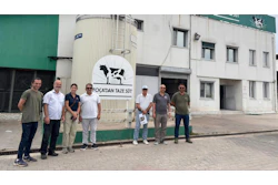 Group of seven men standing in front of Focadan Taze Süt dairy facility with cow logo sign