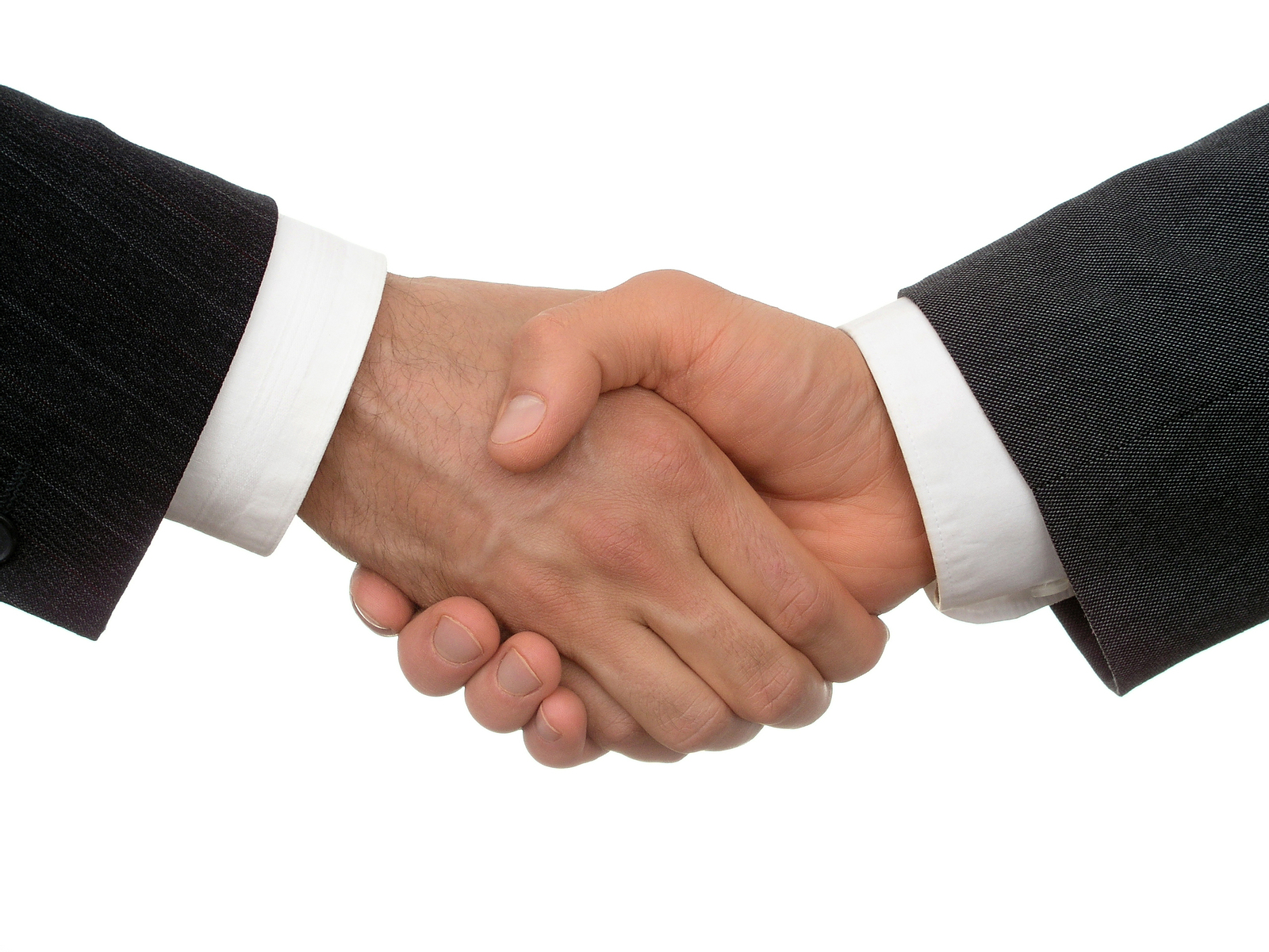Two business professionals in formal attire shaking hands in agreement