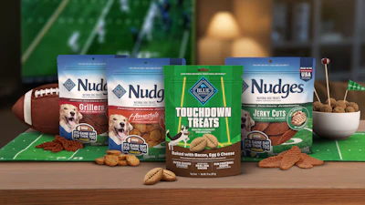 Nudges dog treats product lineup displayed on green football surface with football and accessories