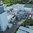 Aerial view of Purina manufacturing facility with multiple industrial buildings, parking areas, and surrounding green landscape