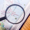 Magnifying glass examining a map showing St Lucia, Barbados, and Bridgetown on an atlas page