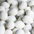 Overhead view of fresh white eggs arranged tightly together