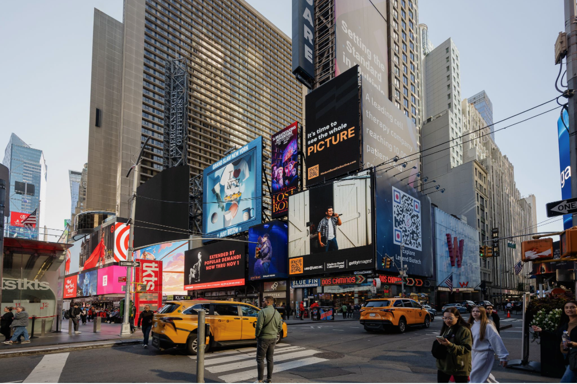 Times Square in New York City with tall buildings, digital billboards, yellow taxis, and crowds of pedestrians