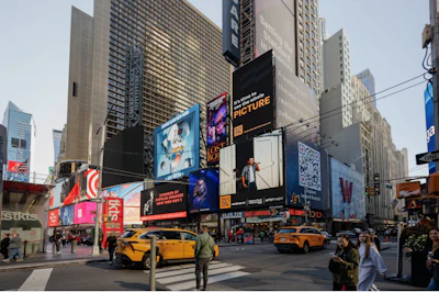 Times Square in New York City with tall buildings, digital billboards, yellow taxis, and crowds of pedestrians