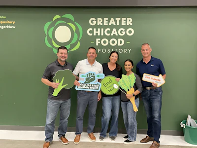 Five volunteers holding food advocacy signs at Greater Chicago Food Depository