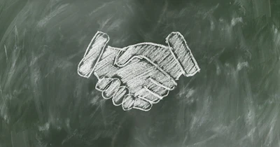 White chalk handshake illustration drawn on a dark green chalkboard background